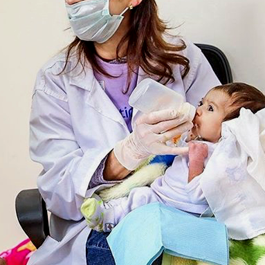 Profesional de salud enseñando técnicas de alimentación y lactancia para bebés con fisura labiopalatina