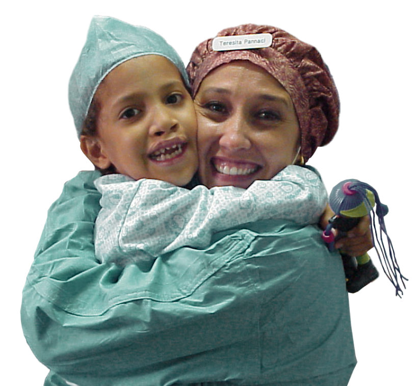 Cirujana maxilofacial sosteniendo a un niño paciente después de una cirugía de fisura labio-palatina