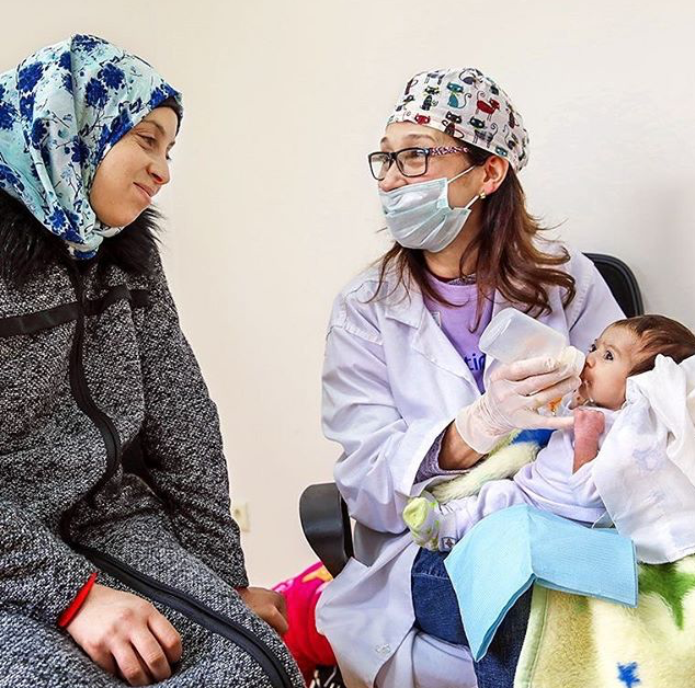 Odontóloga enseñando a una madre técnicas de alimentación adaptada para un bebé con fisura labiopalatina